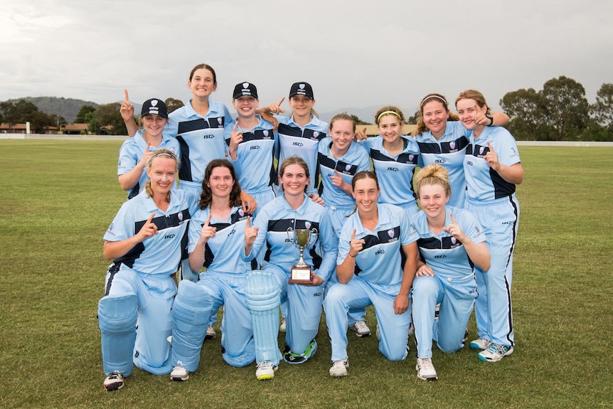 The NSW U18 women's metro team smile with the trophy.