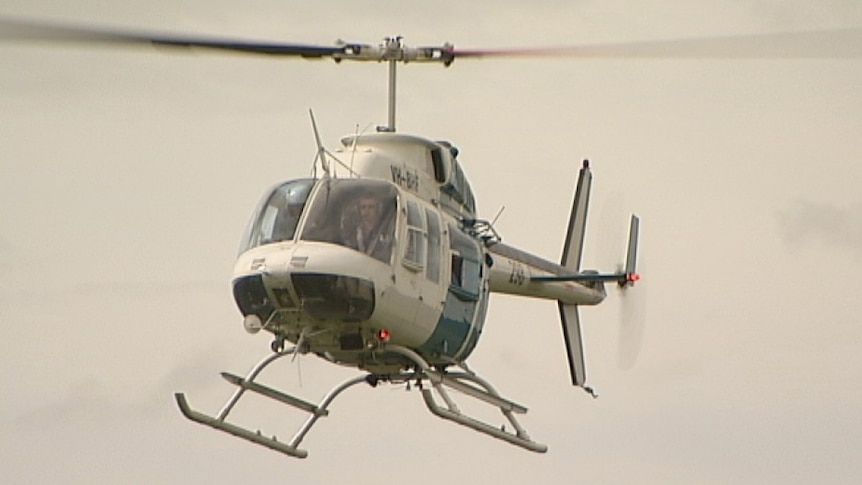 A helicopter is checking along the border for illegal rubbish dumps in remote bushland.