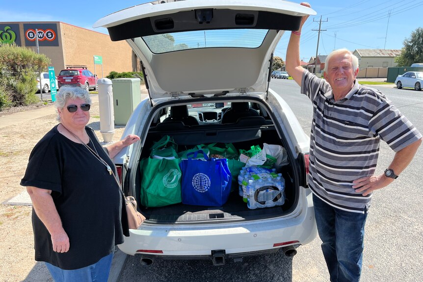 couple with groceries in car boot
