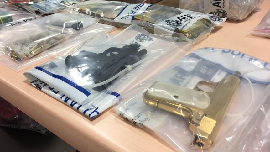 Weapons in evidence bags laid out on a table