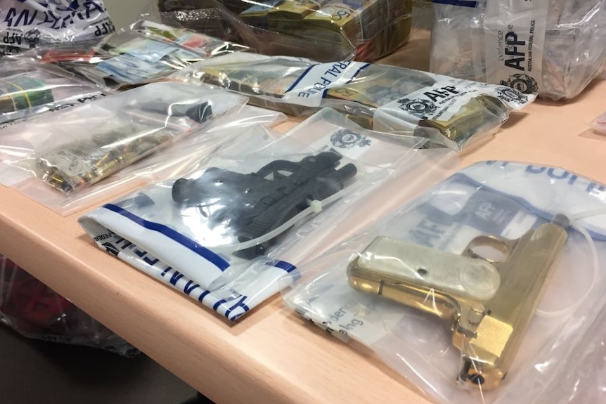 Weapons in evidence bags laid out on a table