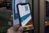 Person uses their phone to scan a QR image.