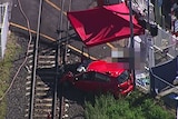 Wreck of red car at a fatal train level-crossing accident on the Cleveland line on Brisbane's bayside
