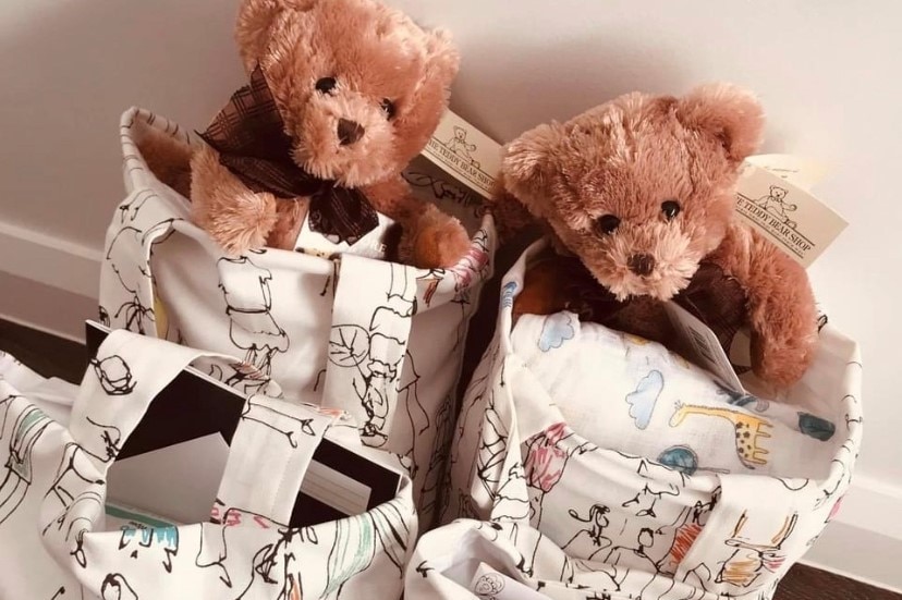Teddy bears poke their heads out of pretty tote bags