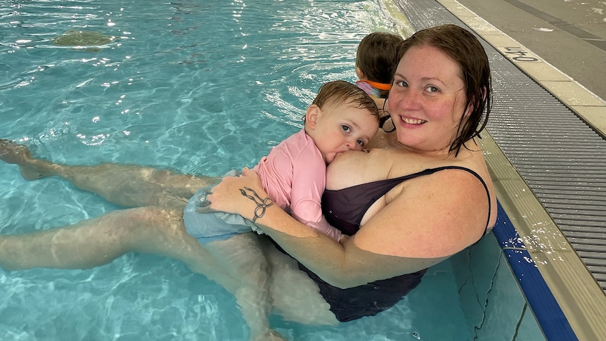 Nicole and her youngest breastfeeding in the pool