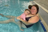 Nicole and her youngest breastfeeding in the pool