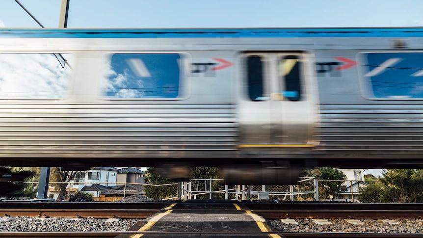 A Metro train speeds through a pedestrian crossing in Melbourne.