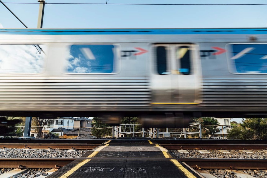 A Metro train speeds through a pedestrian crossing in Melbourne.