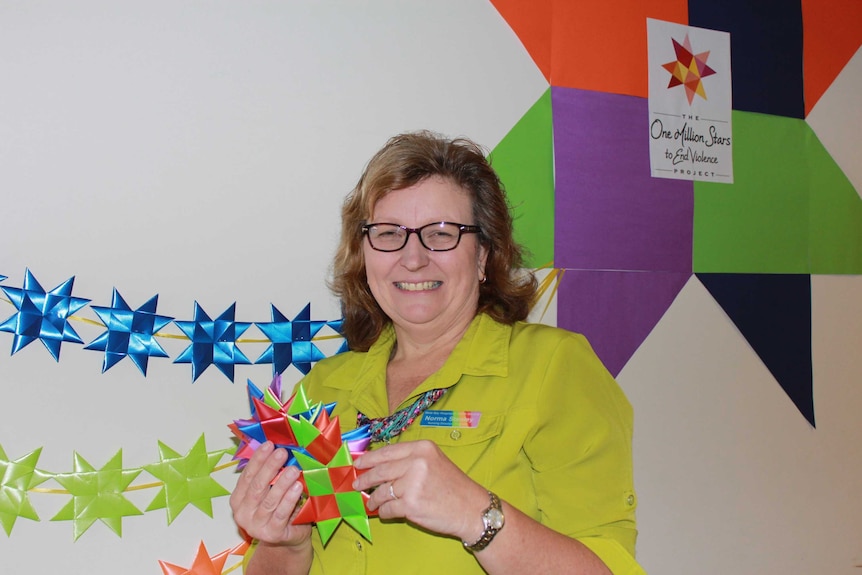 A woman stands in front of a display of woven stars in the Wide Bay Hospital in Bundaberg