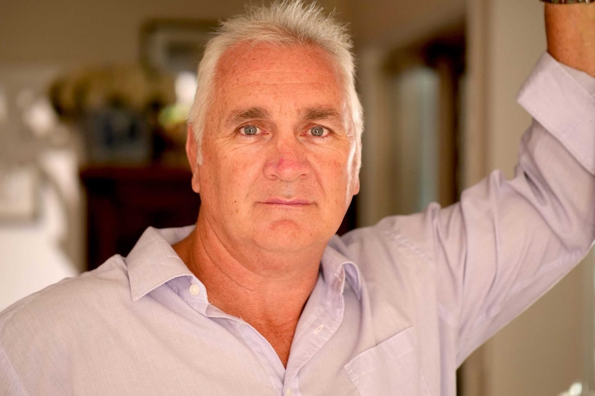 Jason McFetridge stands in a doorway looking towards the camera.