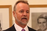 Nigel Scullion gestures with his hands while speaking.