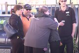 Group of supermarket workers hug each other