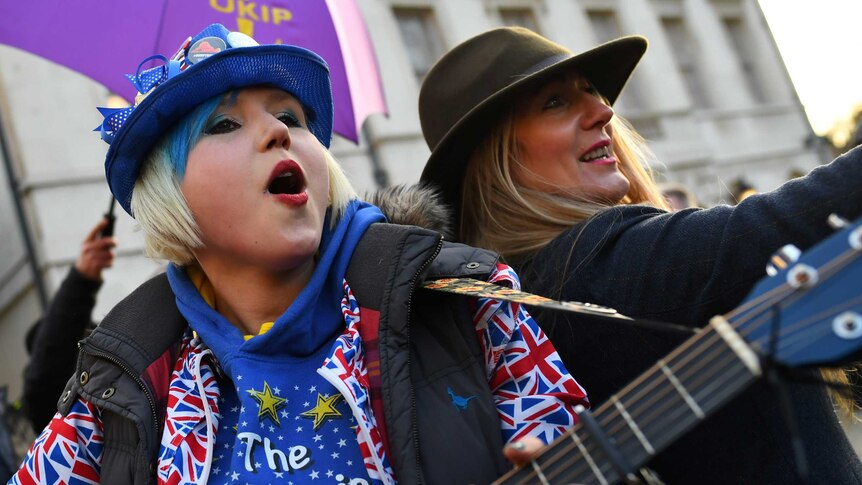 An anti-Brexit protester plays the guitar outside the Houses of Parliament in London.