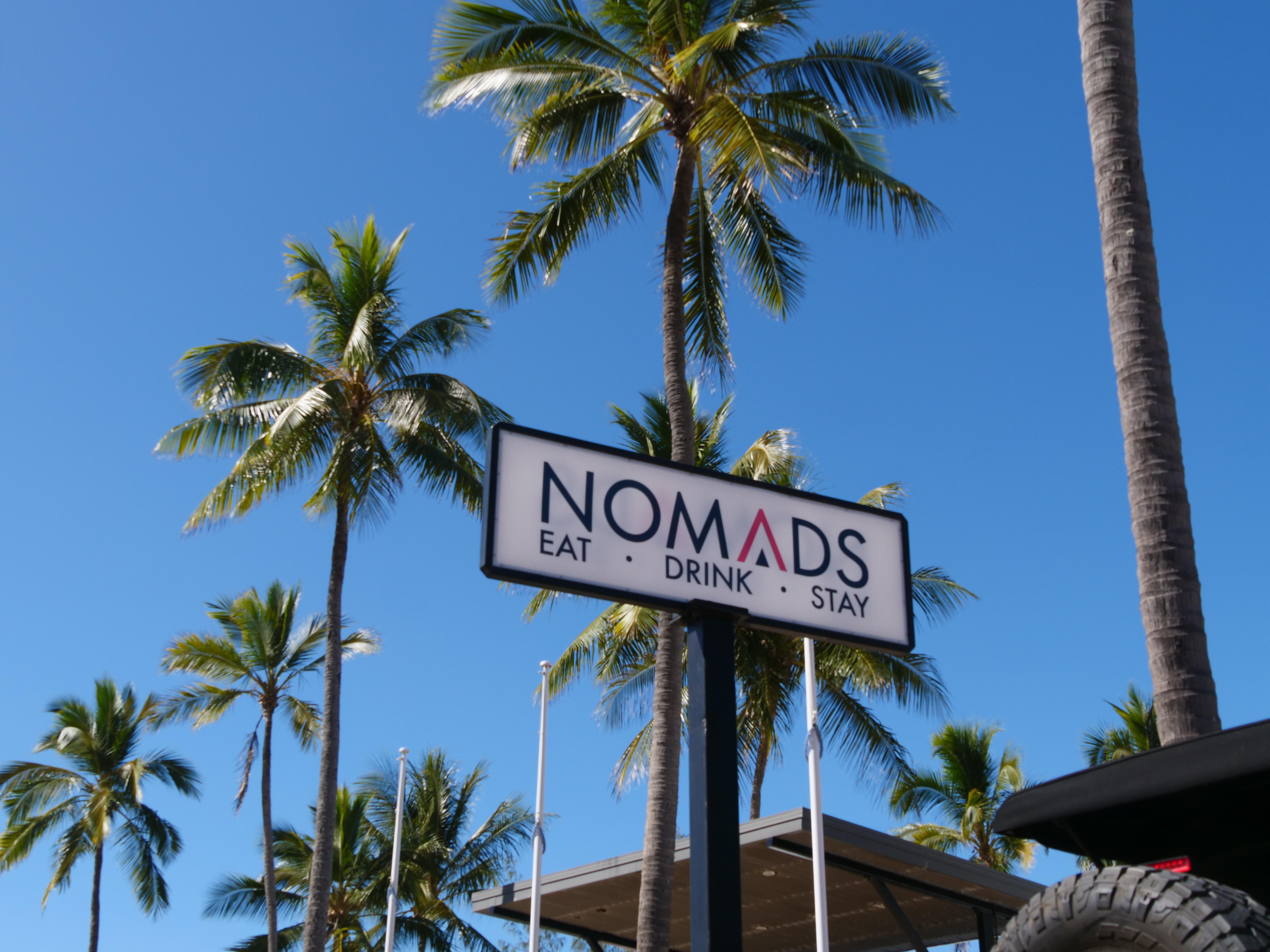 A business sign with palm trees in background