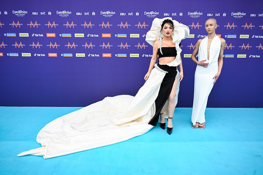 Besa's members, one wearing a white halter neck gown, the other in a long black and white gown with a puffy collar