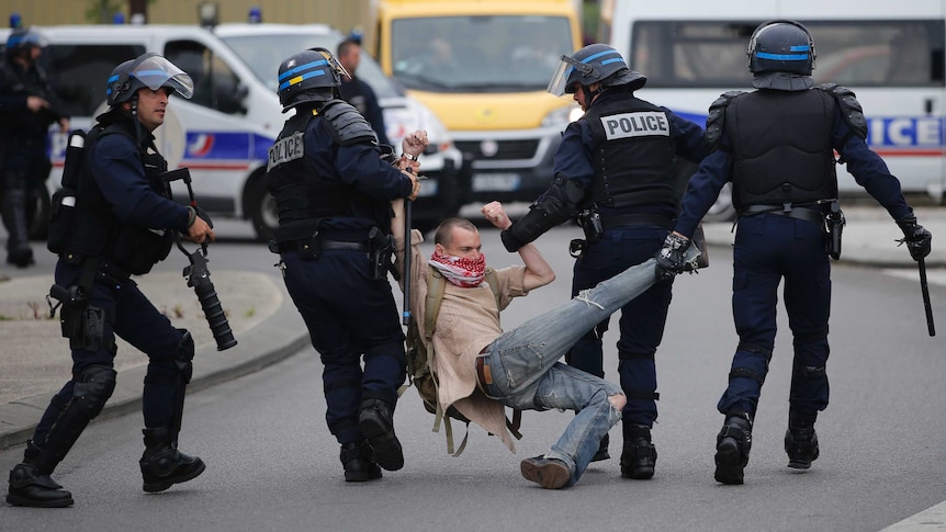 French police apprehend a man during a demonstration.