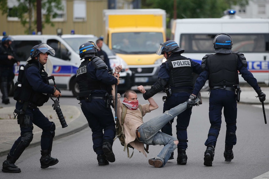 French police apprehend a man during a demonstration.