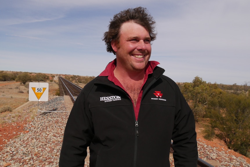 A man smiling in the outback.