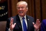 Donald Trump gestures with his hands as he speaks to Congress members.