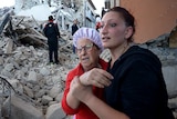 Residents reacts among the rubble after a strong earthquake hit Amatrice on August 24, 2016