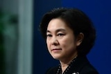 Chinese Foreign Ministry spokeswoman Hua Chunying stands at a lectern during a press conference.