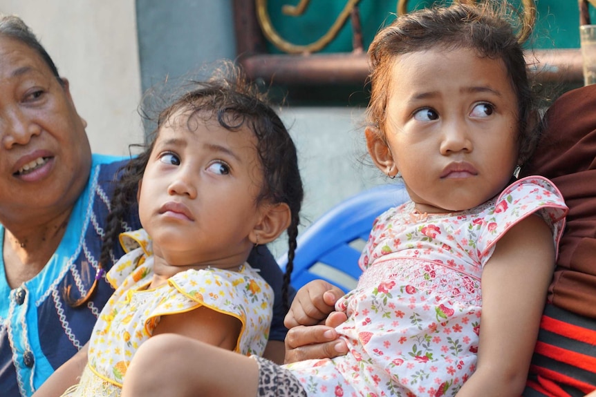 Twins Fani and Fina in Indonesia's twin village. They have just woken up and look grumpy.