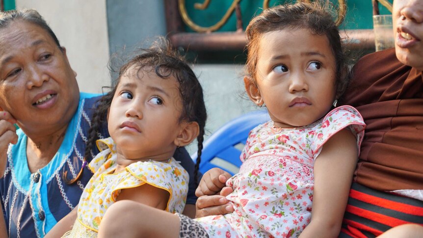 Twins Fani and Fina in Indonesia's twin village. They have just woken up and look grumpy.