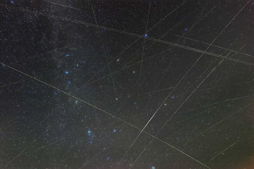 An image of the Perseids meteor shower with lines made by satellites.
