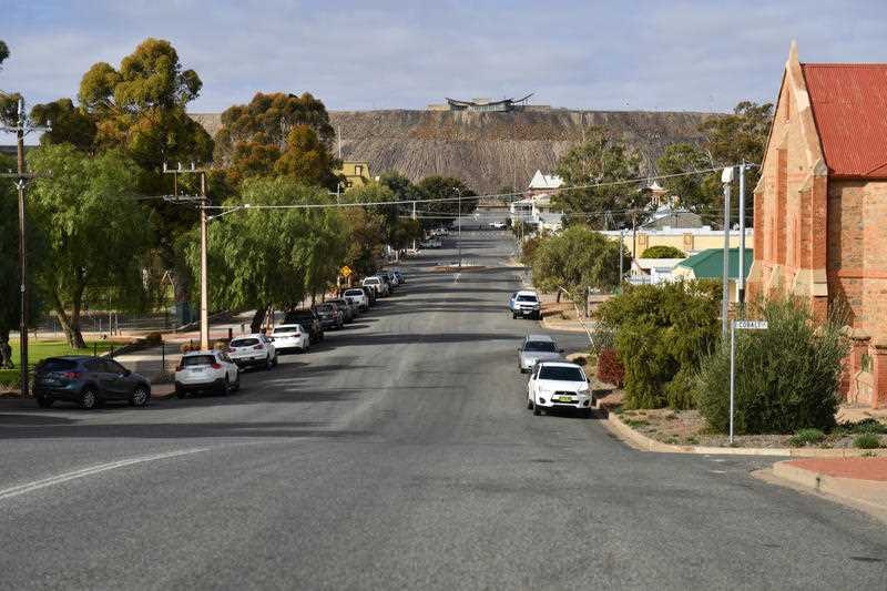A wide street with a mining site at the top