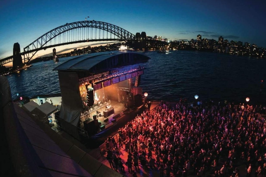 Concert crowd and stage with bridge in background, promo image from Sydney Opera House website.