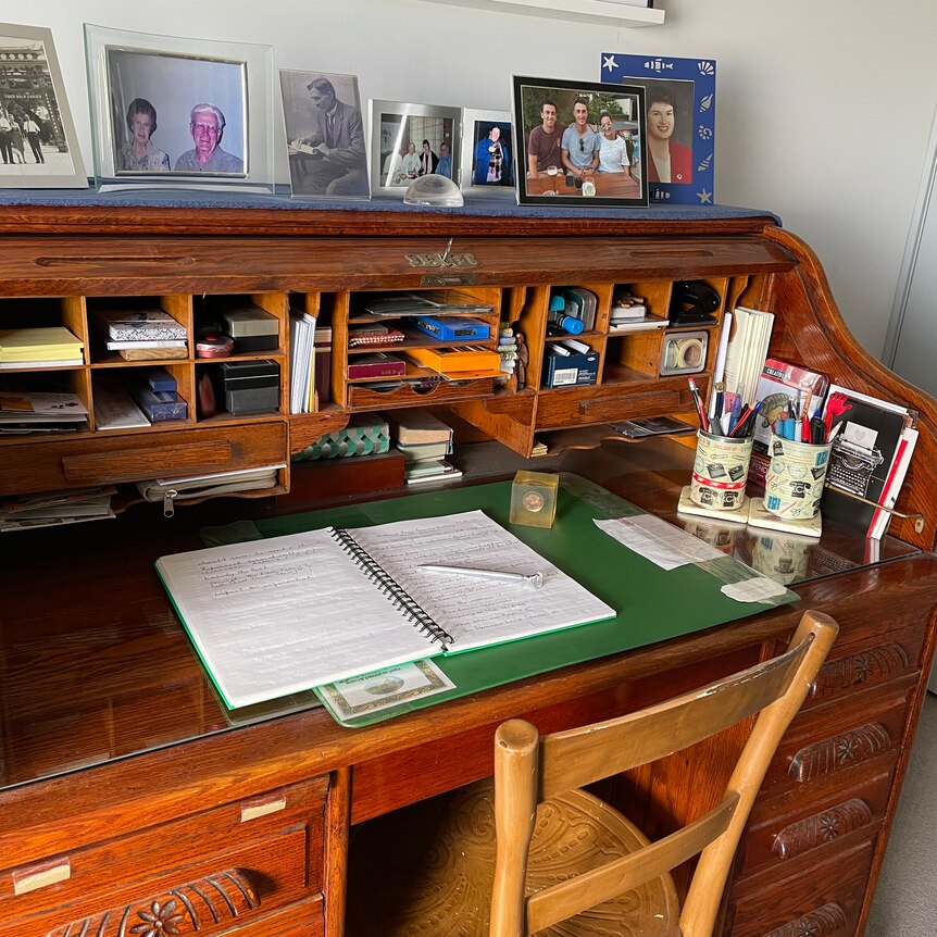 A rolltop desk containing papers and other items