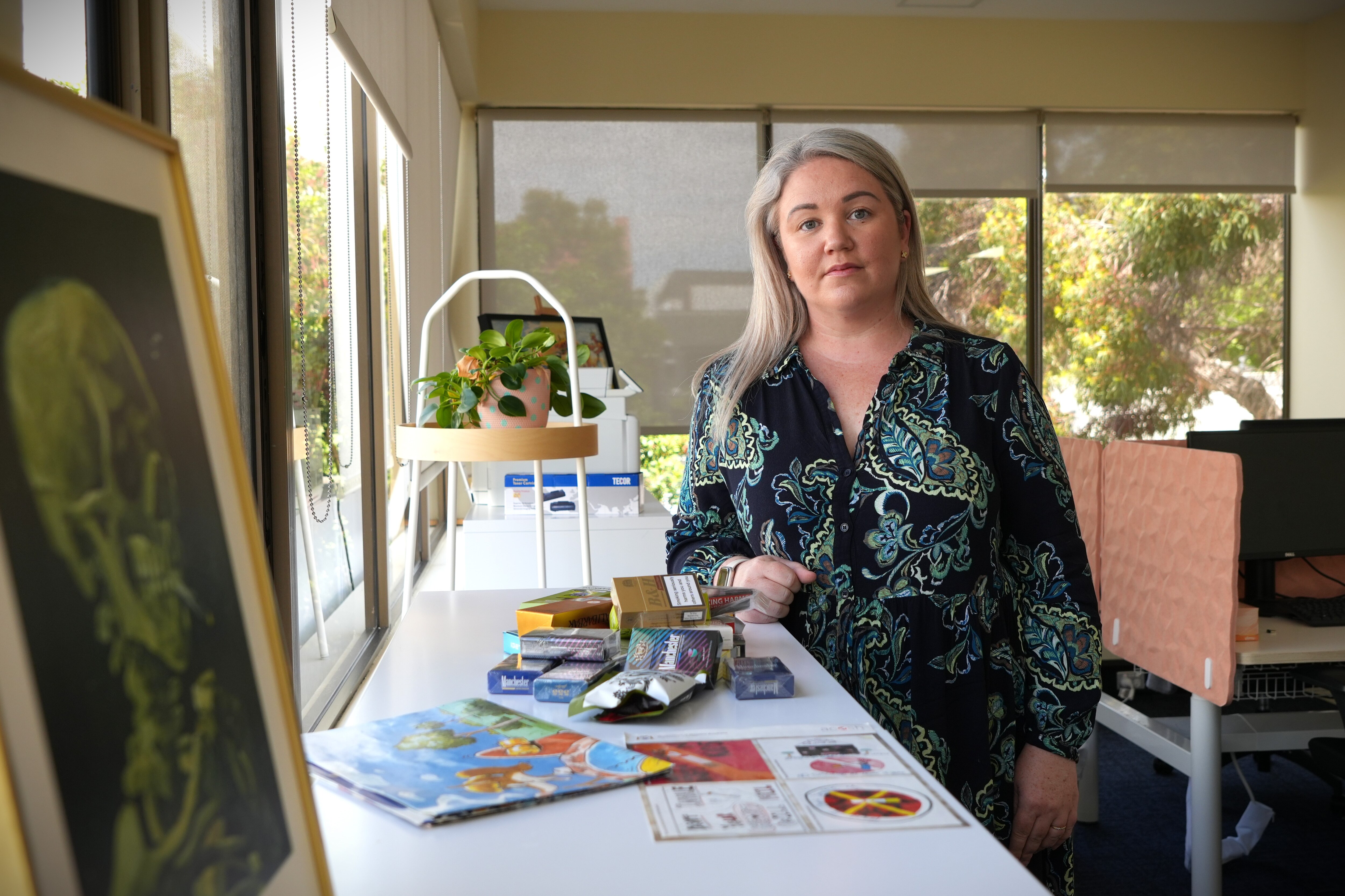 Laura Hunter se encuentra en una oficina junto a una mesa que exhibe cigarrillos ilegales.