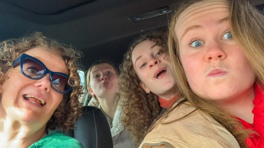 Mandy McCracken with her three teenage daughters in the car, on a interstate road trip as a solo parent.