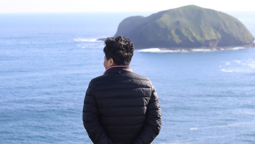 Mr Lu looking out to sea at Cape Grim.