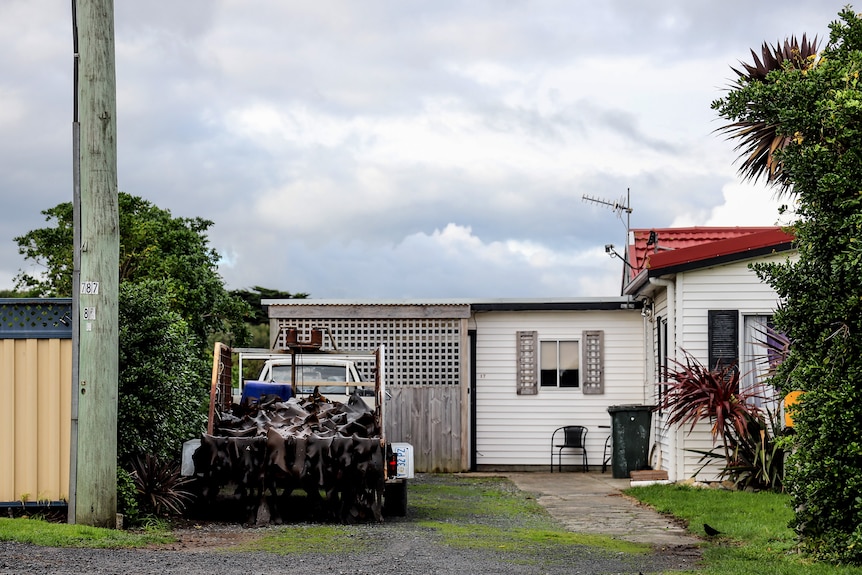 A ute with kelp on the back parked in the driveway of a residential home