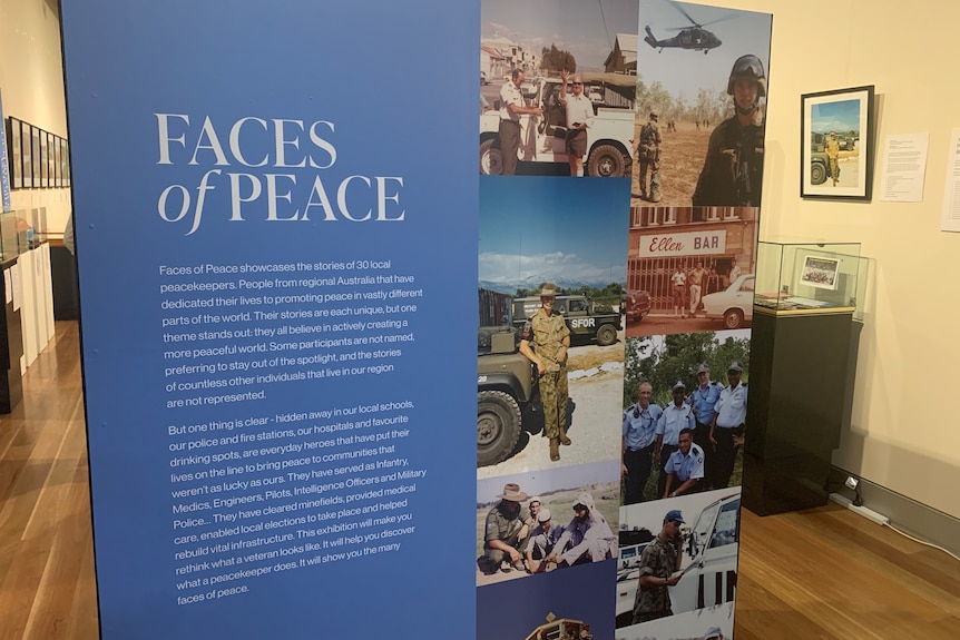 Entrance to a museum exhibition with the title Faces of Peace, text and photographs on signage.