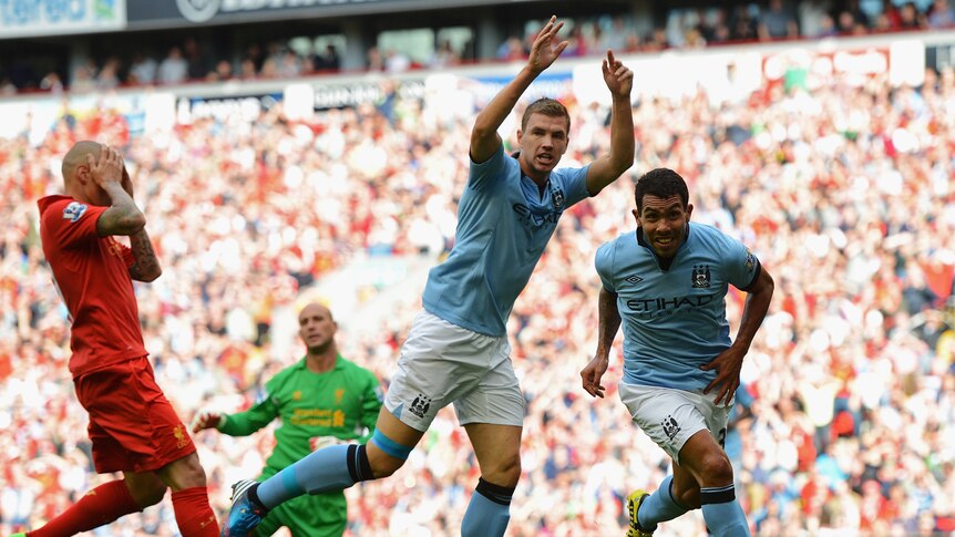 Manchester City's Carlos Tevez (R) celebrates after scoring the equaliser against Liverpool.