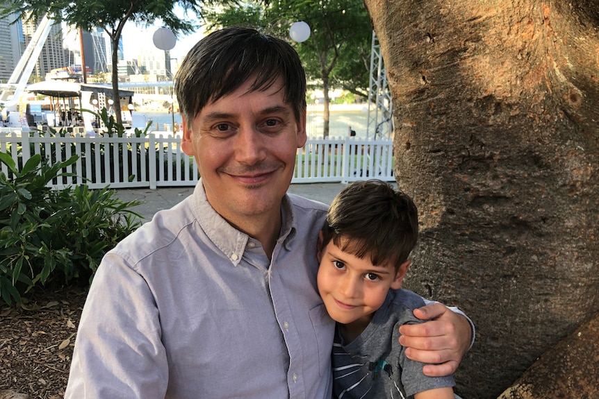 Govinda Lang and his son Zen sit under a tree