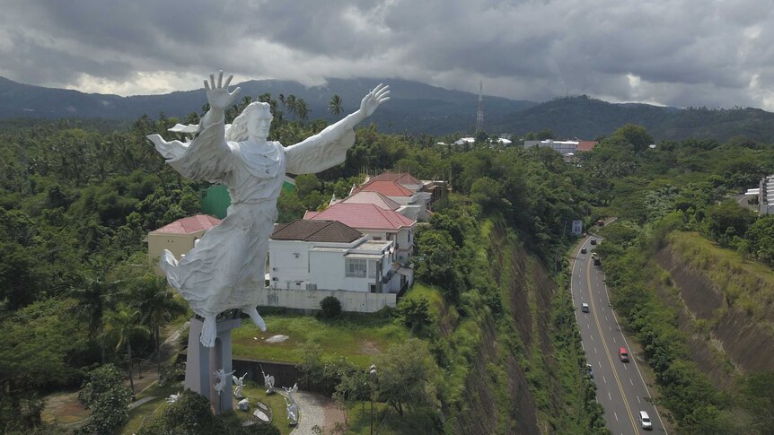 A huge Jesus statue overlooking a tropical locale
