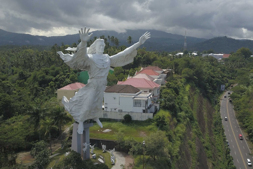 A huge Jesus statue overlooking a tropical locale