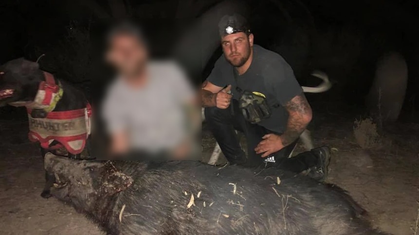 a man poses next to a dead pig at night 