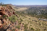 view from the top of a grassy mountain with rocky cliff