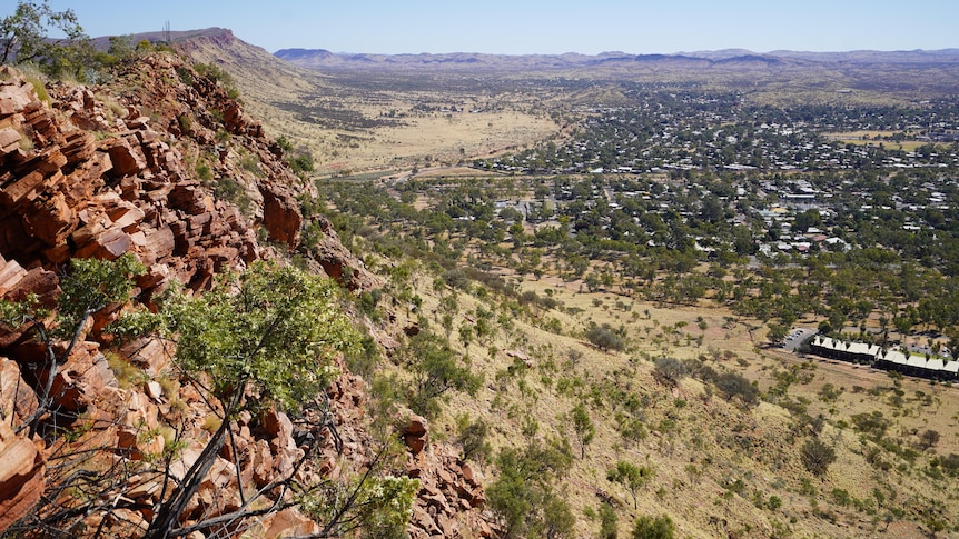 view from the top of a grassy mountain with rocky cliff