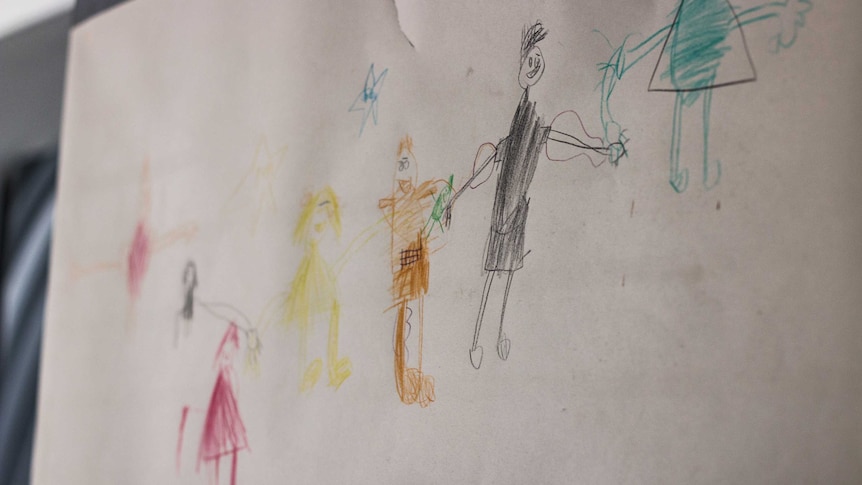 A child's drawing shows a family with a soldier father.