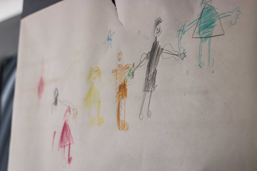 A child's drawing shows a family with a soldier father.