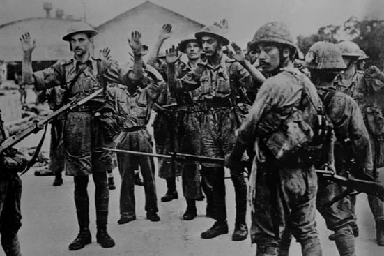Black and white photo of soldiers holds their hands up in surrender 