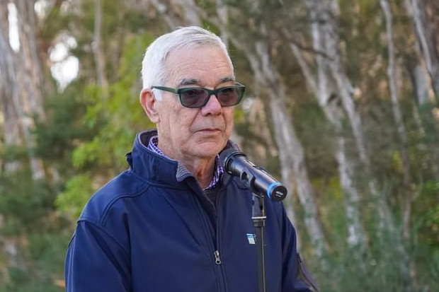 a man wearing glasses speaks into a microphone