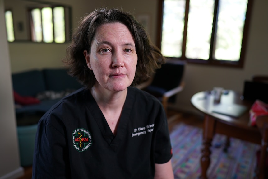 Clare Skinner wearing black scrubs and looking pensive.