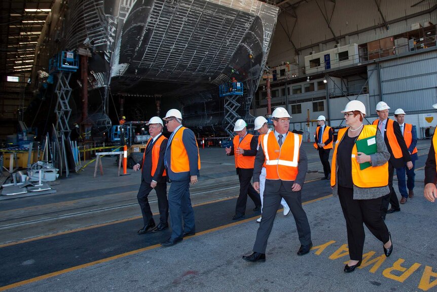 The WA Premier and Federal defence Minister Marise Payne walk through Henderson base with the hull of a ship in the background.