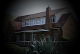 A picture of an older two-storey house with a black shadow around the edges.